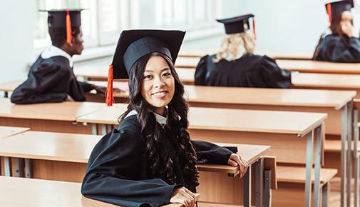 学生 in graduation attire in the classroom